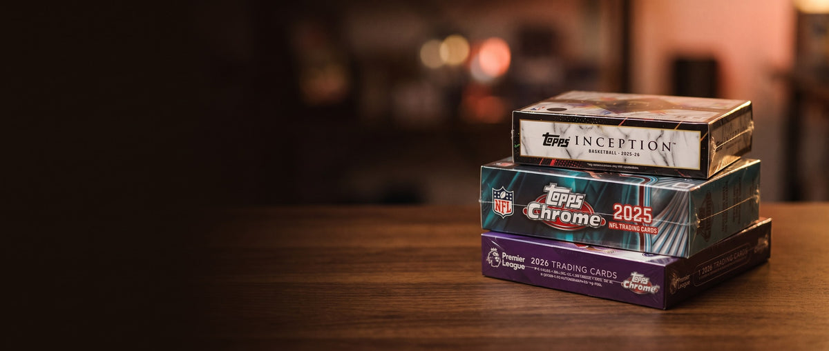 Gestapelte versiegelte Topps Hobby Boxen auf einem dunklen Holztresen im warmen Abendlicht